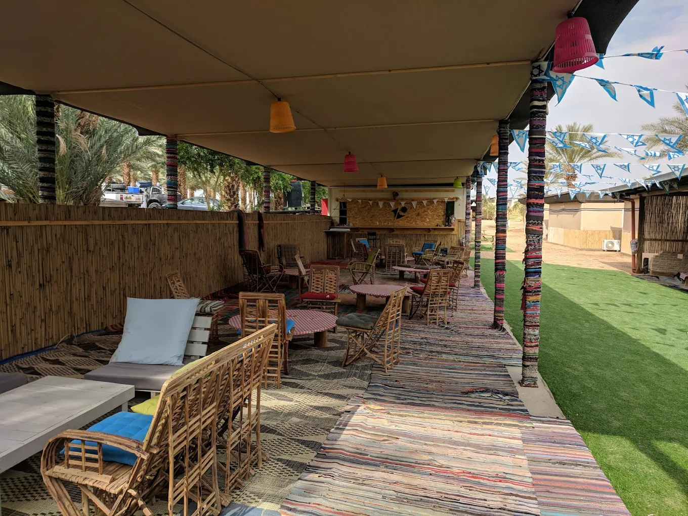 מתחם לאונג׳ בדואי עם שטיחים, כריות ופנסים בחאן בערבה